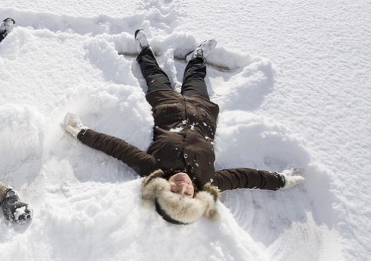 Man and woman making angels in the snow
